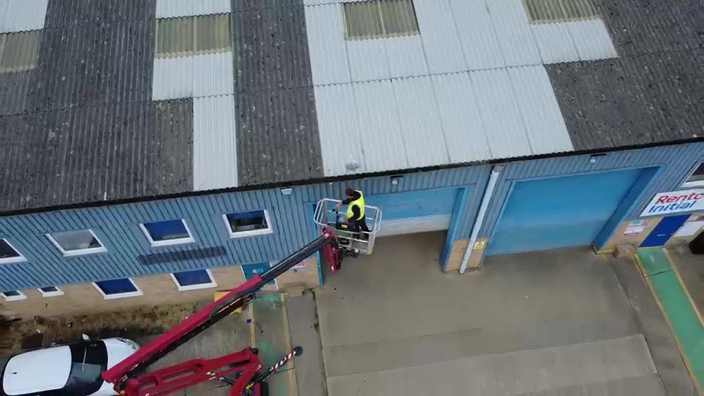 Drone view of our operator clearing an industrial roof from the tracked spider lift basket